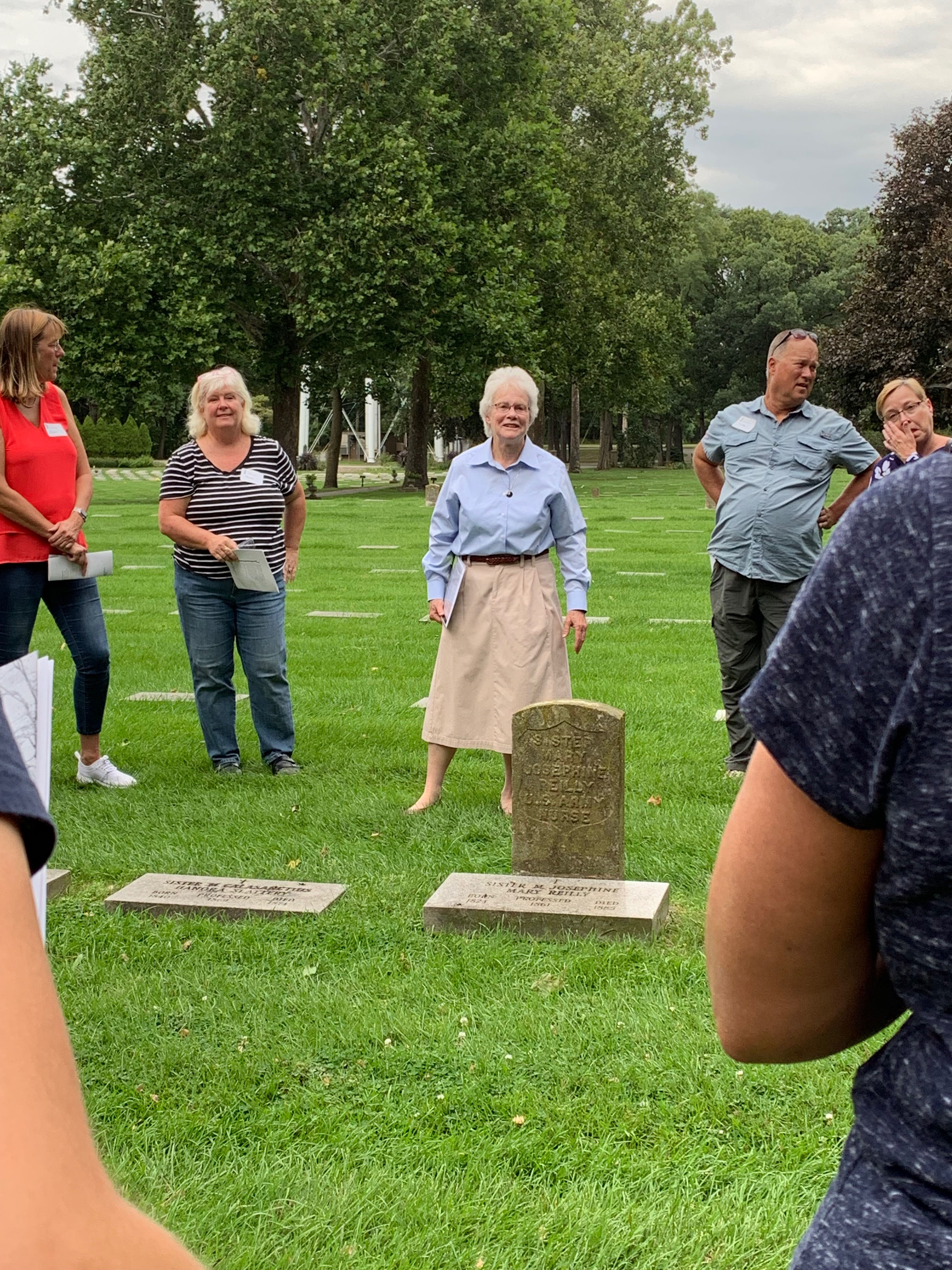 Pilgrims reflect at the gravesite of Sister Madeleva