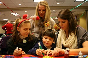 Brittney Sego, 12, and her brother, Andy, 6, make crafts with nursing juniors Kari Keller, standing, and Elizabeth Mueller at a Pediatric Respite Program Christmas party held at the College in December 2011. 