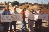 students holding up hand-made signs protesting