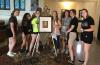 a group of high school students at the Embody Summer Theology Institute at Saint Mary’s College stand around a portrait of Bl. Basil Moreau in the chapel.