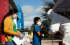 Kenneth Midoneck, lead community health worker with Healthcare Network, tests Santos Pablo, center, for Covid-19 alongside his mother Juliana Pablo and brother Edvyn Aguilar during a mobile health clinic put on by Healthcare Network in Immokalee, FL on Saturday, Dec. 5, 2020.